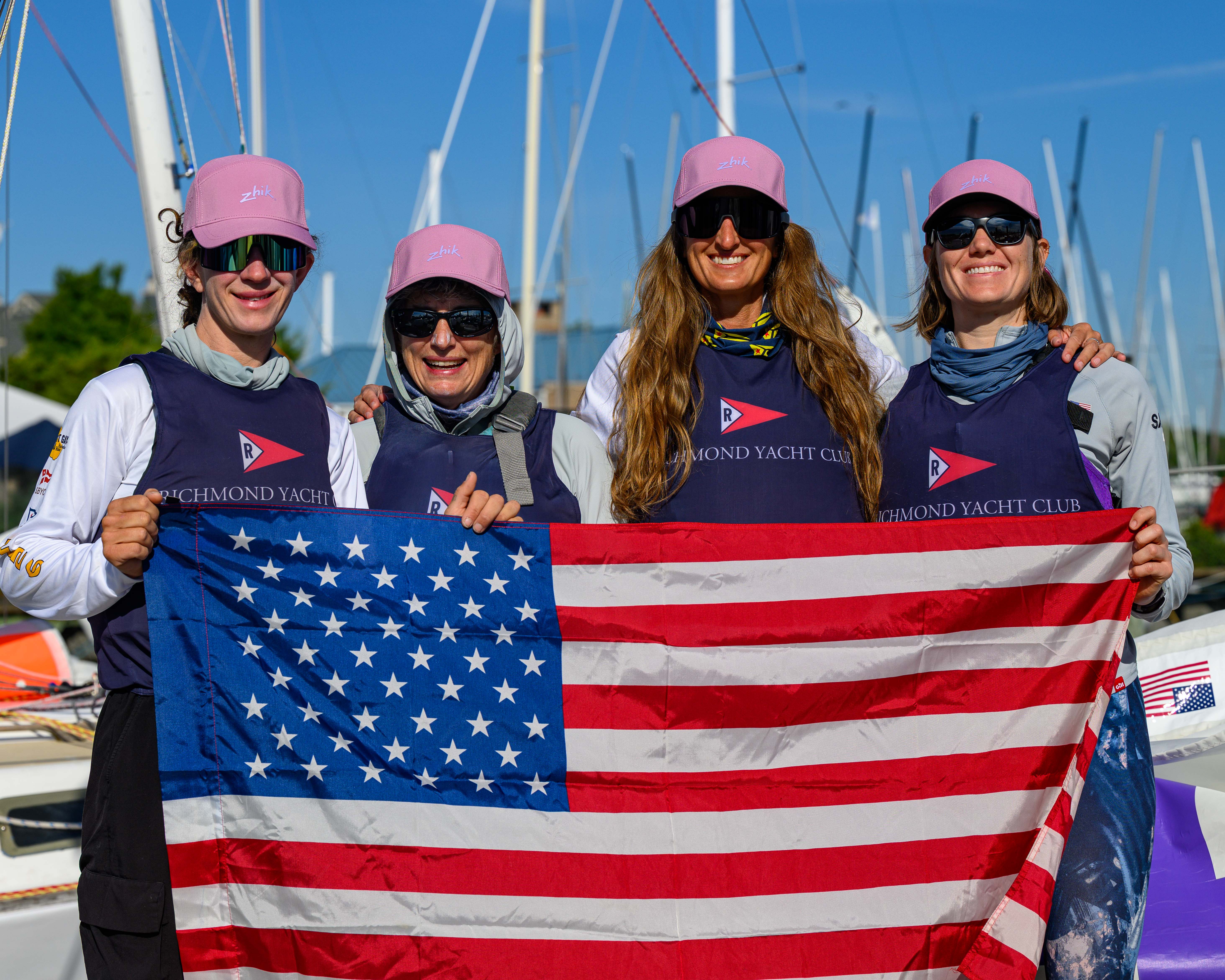 Team USA crew holding the American flag dockside